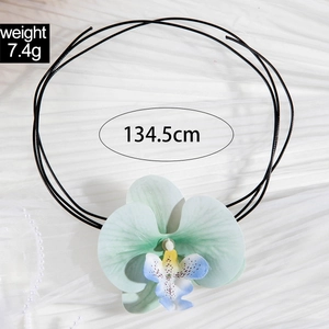 Détail d'un pendentif orchidée sur cordon avec mesures de poids et de longueur incluses