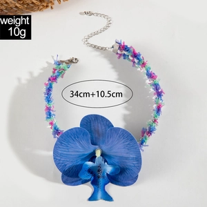 Détail de pendentif orchidée bleue avec cordon en tissu coloré et fermoir en argent