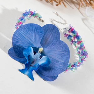 Détail du collier orchidée bleue bohème avec tour de cou en tissu tressé et fermoir métallique