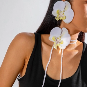Détail d'une parure de bijoux orchidée blanche avec tour de cou et boucles d'oreilles