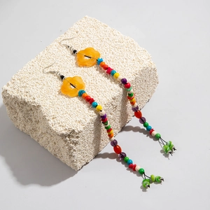 Detail of bohemian long tassel earrings with yellow floral beads and colorful beadwork