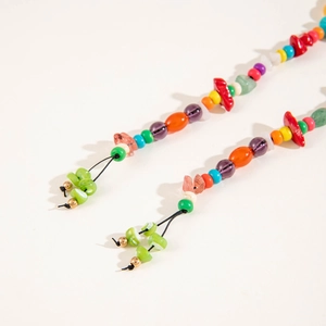 Macro detail of Bohemian style colorful beads with green leaf charms and gold accents