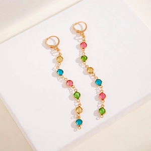 Detail of bohemian long drop earrings with colorful round stones and gold finish