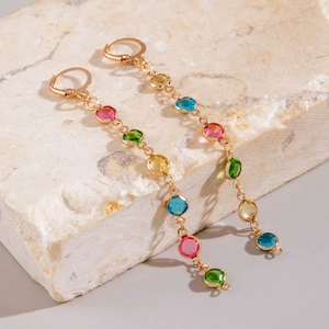 Detail view of Bohemian tassel earrings with colorful stones on natural stone base