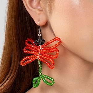 Detailed close-up of handmade Bohemian beaded earrings with vibrant red and green tassels