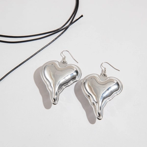 Macro shot of silver liquid lava heart earrings with high-gloss metallic finish