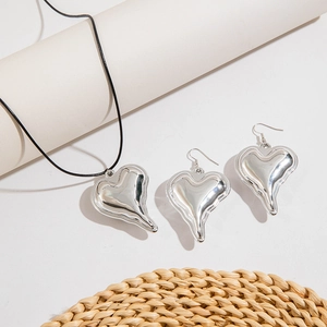 Detail view of silver liquid metal heart pendant jewelry set with woven cord necklace