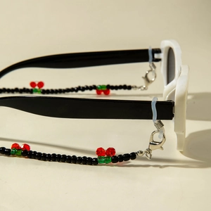 Detail of beaded glasses chain featuring red cherry beads and silver lobster clasps