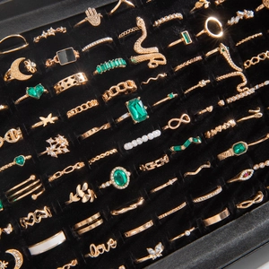 Bohemian gold ring set with green zircon, snake, moon and heart charms on black velvet