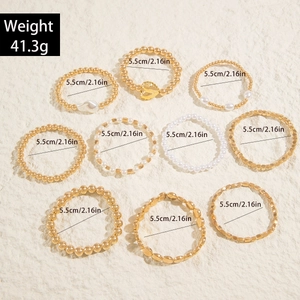 Vue détaillée d'un ensemble de 10 bracelets en perles dorées avec breloques cœur