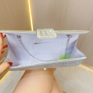 Dettaglio pochette da sera con paillettes argento, fibbia in strass e catena in metallo
