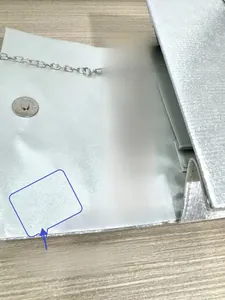 Detail of silver evening clutch showing high-density satin lining and reinforced stitching