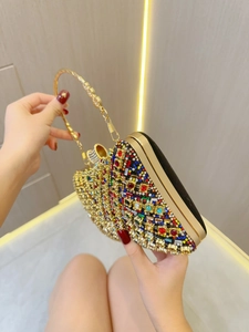 Luxury evening clutch bag with multicolored rhinestones and golden curved handle