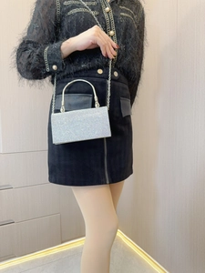 Silver rhinestone evening clutch bag with round metal handle shown as a stylish handbag