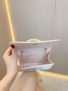 Elegant ivory pleated evening clutch bag with large pearl handle and silver chain strap