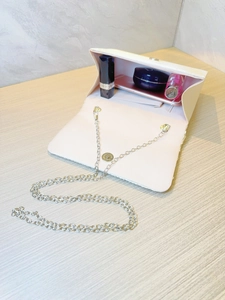 Elegant cream pleated evening clutch with silver chain strap and magnetic flap closure