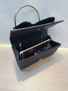 Détails de la pochette de soirée noire montrant l'espace pour smartphone et cosmétiques