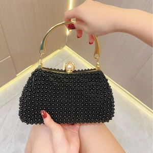 Detailed close-up of a black beaded evening clutch with gold metal handles and top pearl clasp