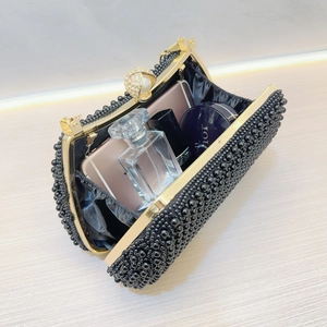 Internal view of black pearl evening bag showing space for phone and perfume