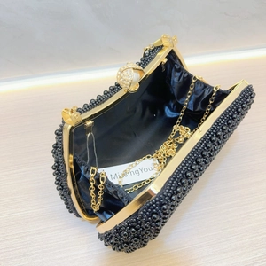 Macro shot of black beaded evening bag featuring gold hardware and a rhinestone clasp