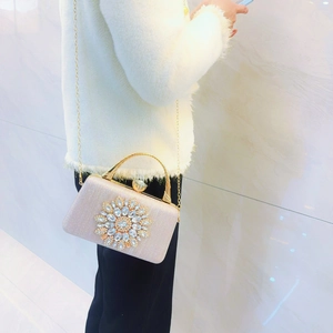 Detail of light pink evening bag with rhinestone sunflower and gold chain strap