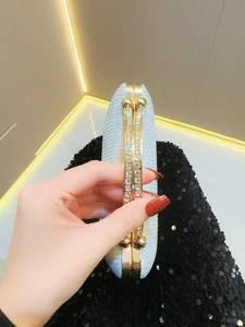 Detail of silver glitter clutch bag with gold frame and sparkling diamond clasp for parties