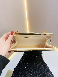Detail view of gold evening clutch interior with chain strap and lining pocket