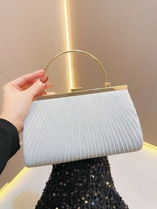 Detail of pleated evening clutch bag with gold ring handle and shimmering blue fabric