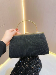 Detail of black pleated evening bag with sparkling sequins and gold ring handle