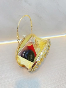 Dettaglio interno di una borsa da sera dorata con strass che mostra la capacità di contenimento