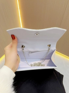 Elegant silver evening clutch bag with sparkling finish and wavy flap design shown open