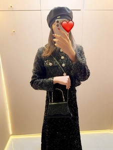 Mirror selfie showing a black sequin evening dress with a rhinestone chain handbag