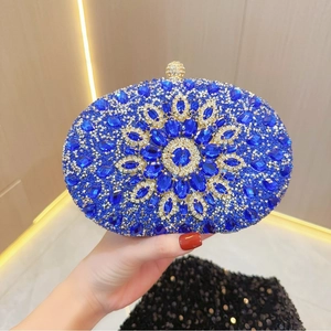 Dettaglio della pochette ovale blu reale con strass a raggiera e chiusura a sfera in metallo