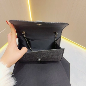 Detail view of black sequin evening clutch bag with magnetic closure and inner pocket