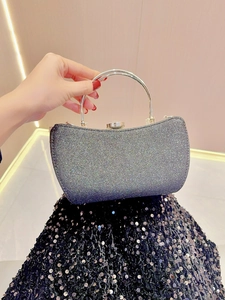 Detail of silver sparkling evening bag featuring a round metal handle and sequined bottom