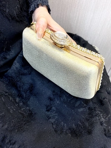 Close-up of champagne gold rhinestone evening clutch with large crystal clasp detail