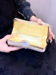 Macro detail of the sparkling rhinestone clasp and satin lining of this evening clutch bag