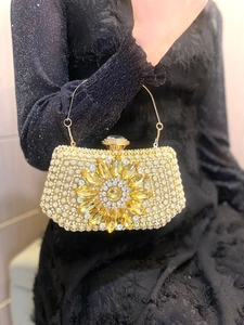Detailed view of luxury evening clutch with large yellow crystal sunflower design and rhinestones
