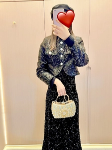Detail of light gold rhinestone evening clutch bag paired with black sequined formal dress