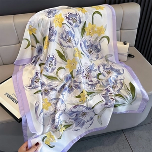 Detail of silk satin beach shawl featuring purple tulips and yellow daffodils on ivory base