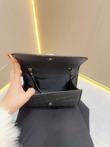 Elegant black sequin evening clutch bag with a silver chain strap and magnetic closure