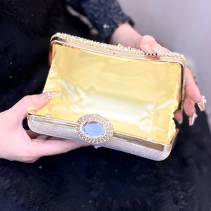 Elegant silver rhinestone evening clutch bag with crystal clasp shown held in hand