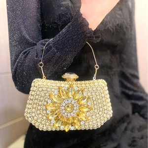 Sparkling gold evening clutch bag with rhinestone floral detail and metal ring handle