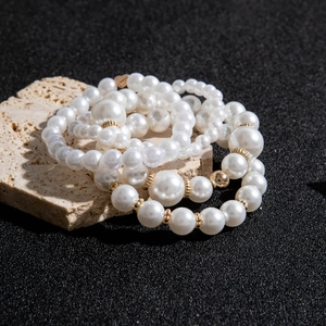 Gros plan d'un ensemble de bracelets en perles multicouches avec breloque cœur dorée