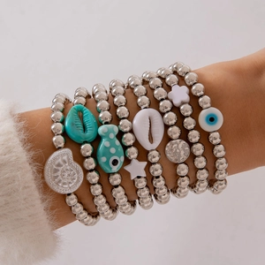 Détail d'un ensemble de bracelets en perles multicouches avec breloques œil et coquille