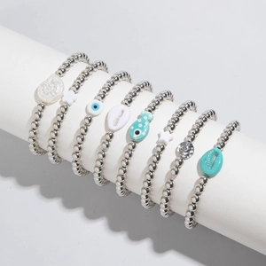 Détail d'un ensemble de 7 bracelets en perles avec breloques cœur, étoile et œil bleu