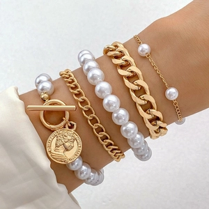 Détail d'un ensemble de cinq bracelets en perles multicouches avec chaînes dorées