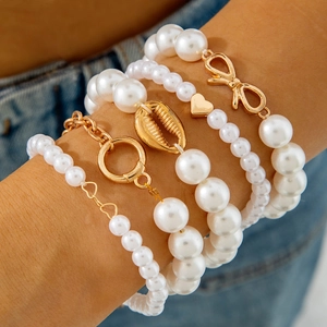 Détail d'un ensemble de 5 bracelets en perles multicouches avec breloques dorées
