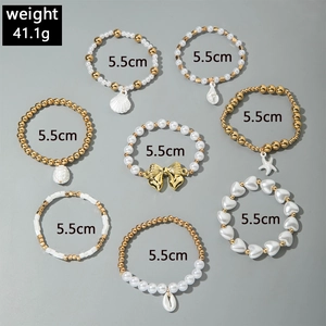 Détail d'un ensemble de 8 bracelets multicouches avec perles et pendentifs dorés