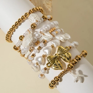 Détail de l'ensemble de bracelets en perles multicouches avec breloque nœud doré